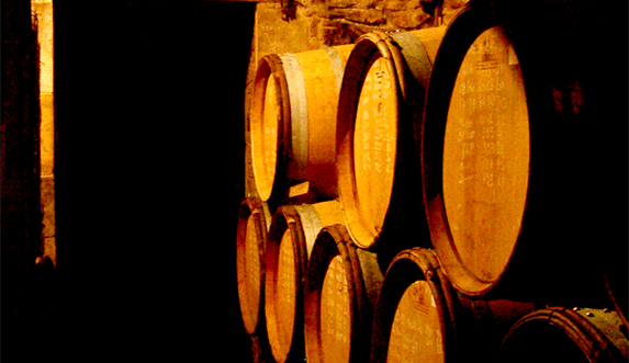 Photo couleur de tonneaux de vin dans une cave à Vergisson, Bourgogne